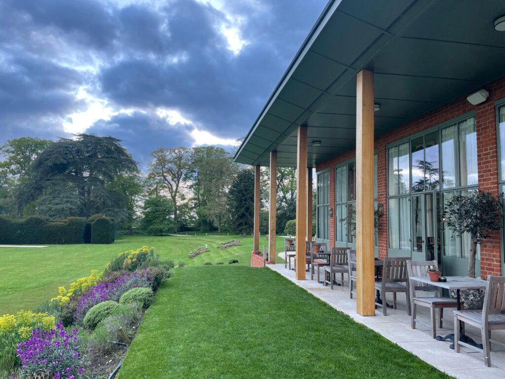 An outdoor shot of The Retreat at Elcot featuring a green lawn and sheltered seating
