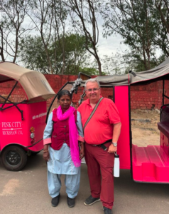 A Red Blaze rep and a Pink City Rickshaw driver in front of a rickshaw