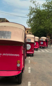 A shot of rickshaws driving in a line through the street