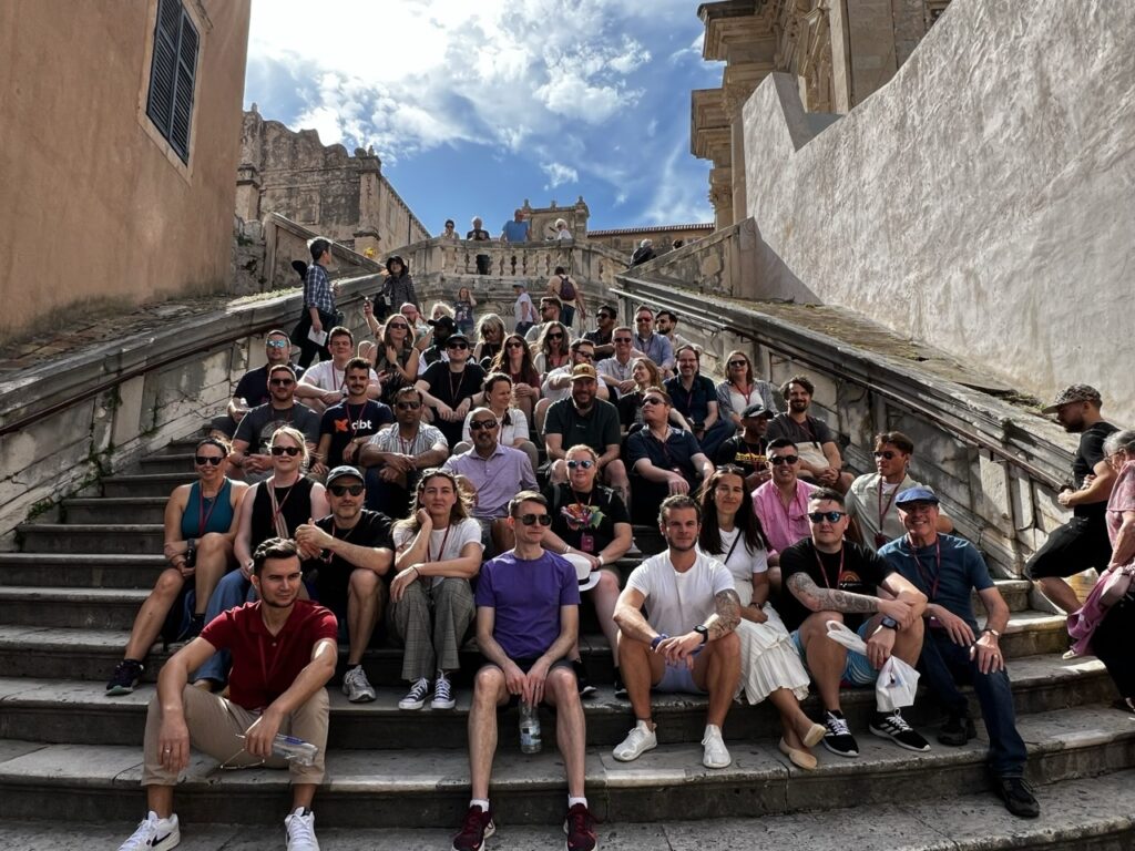 The InterWorks team sat on stone steps in Dubrovnik